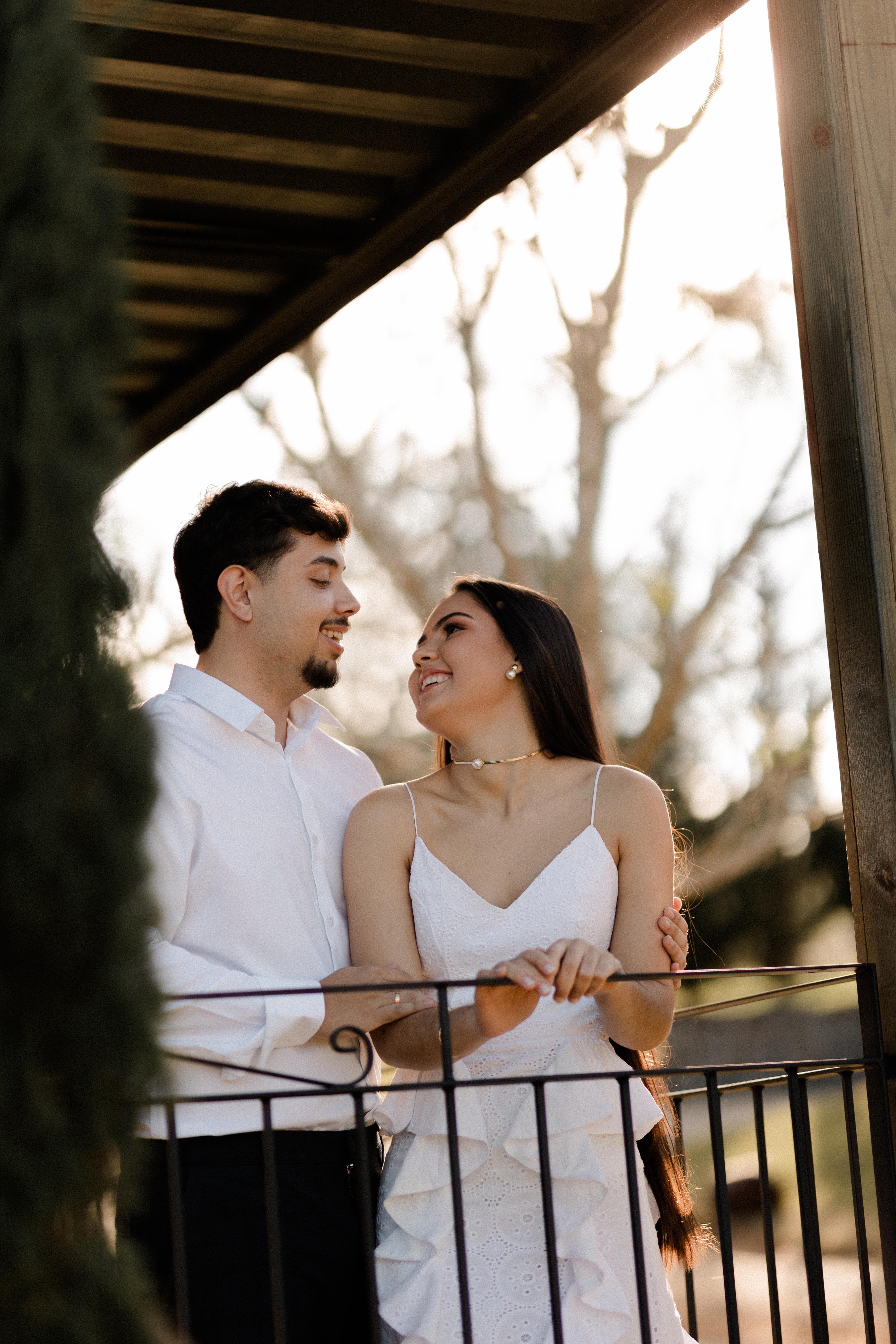 Casal sorrindo no gazebo ao pôr do sol